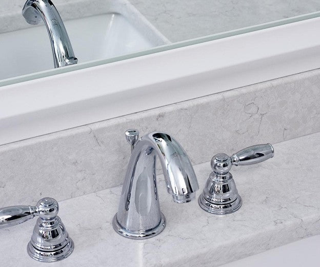 White Frame on a Bathroom Mirror with Chrome Bathroom Fixtures