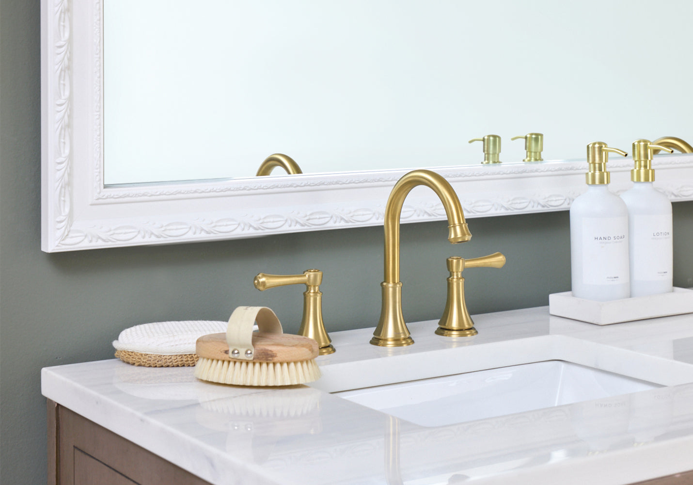White Ornate Bathroom Mirror Frame Next to a Gold Fixtures