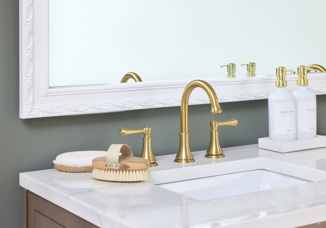 White Ornate Bathroom Mirror Frame Next to a Gold Fixtures