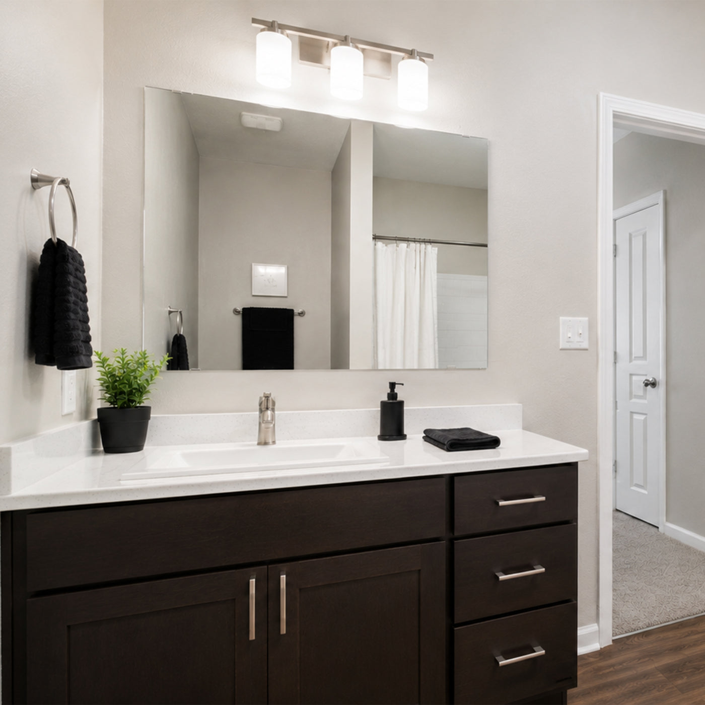 Apartment bathroom vanity with an unframed plate glass mirror