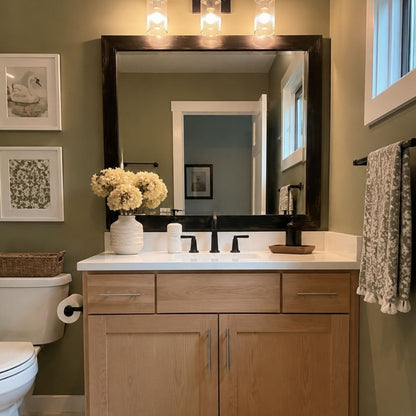 Cherokee Espresso Walnut MirrorMate frame above a light wood vanity in a sage green bathroom