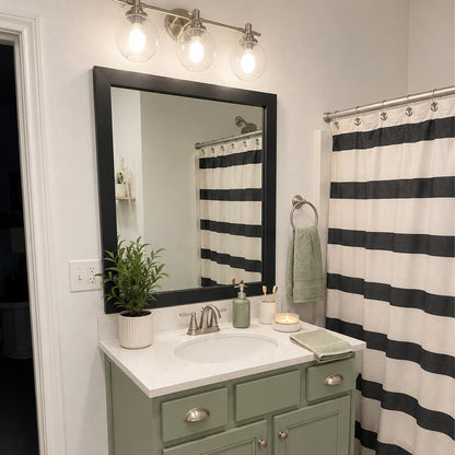 Highline Paintable Slim MirrorMate bathroom mirror frame above a sage green single vanity