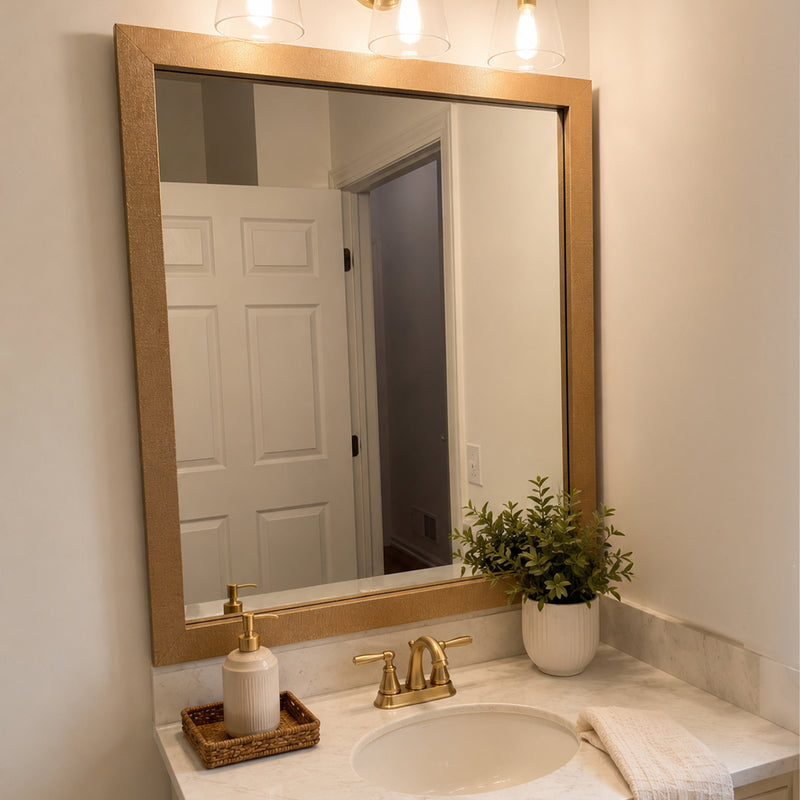 Highline Woven Gold Slim MirrorMate bathroom mirror frame above a white single vanity with warm gold fixtures