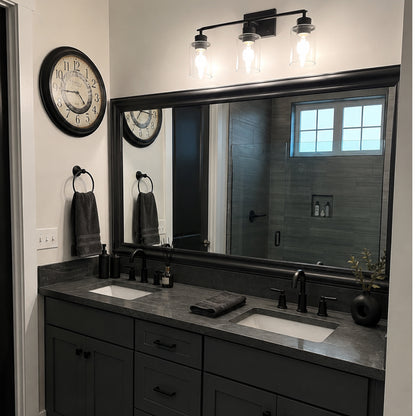 Hudson Midnight Steel MirrorMate bathroom mirror frame above a black double vanity in an industrial-style bathroom