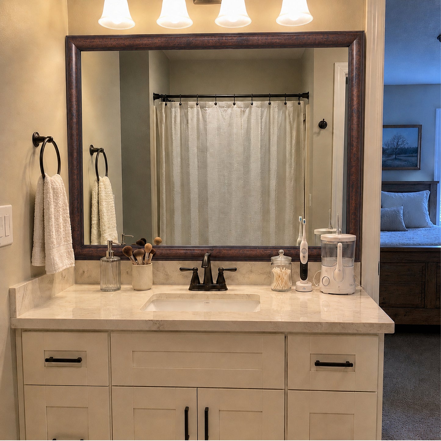 Pemaquid Dark Bronze MirrorMate bathroom mirror frame above a white single vanity