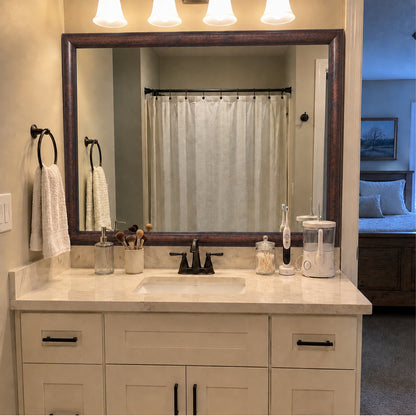 Pemaquid Dark Bronze MirrorMate bathroom mirror frame above a white single vanity