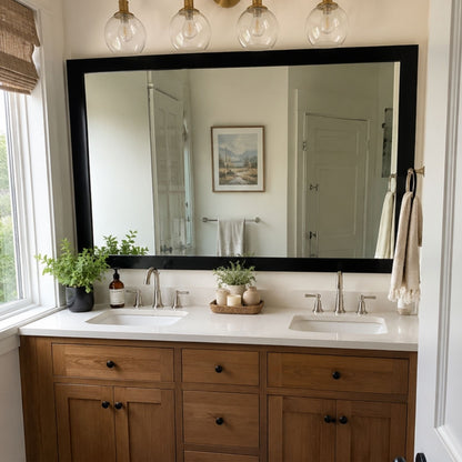 Soho Matte Black MirrorMate bathroom mirror frame above a natural wood double vanity